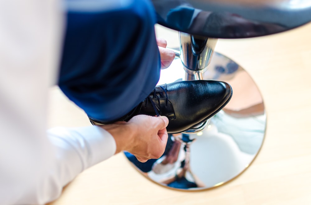 person wearing black dress shoe