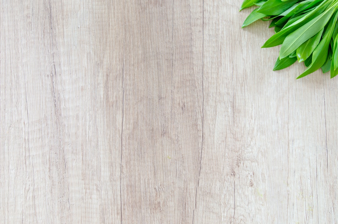 green leafed vegetable on brown wooden surface, Fresh wood garlic on wood
