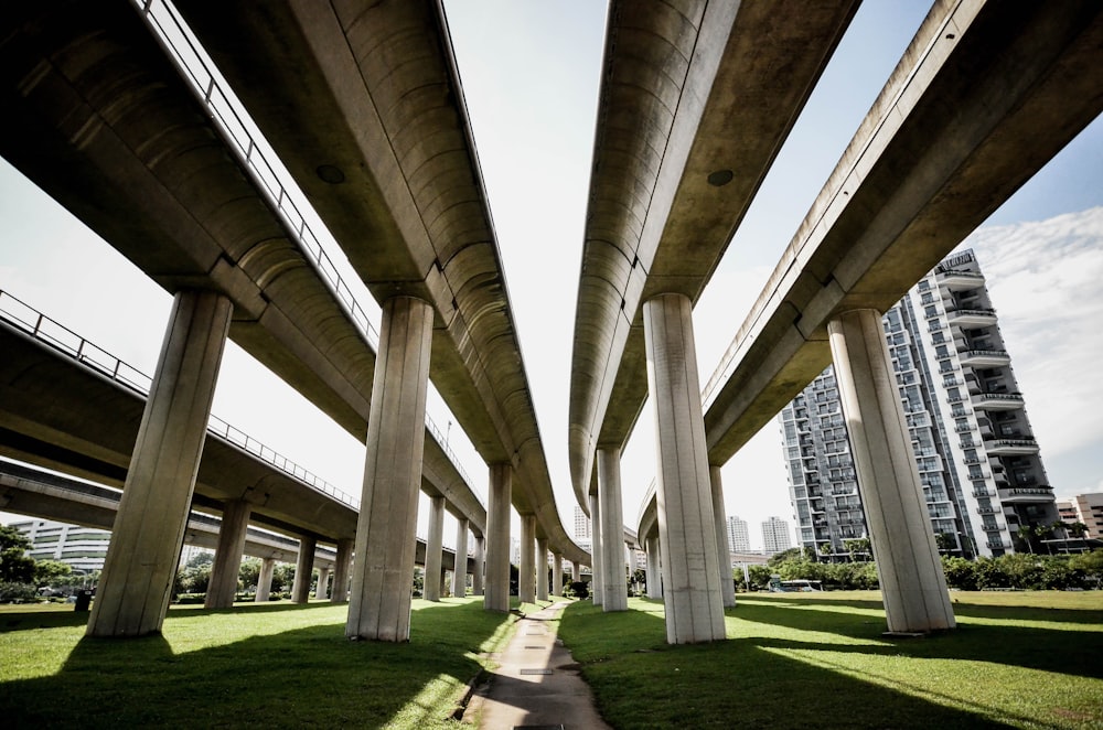 gray concrete train rail on green grass field near building