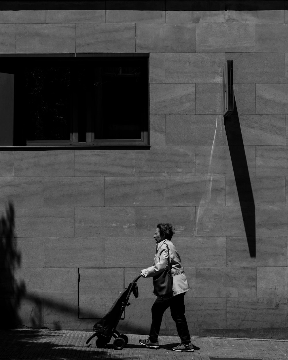 grayscale woman walking with stroller