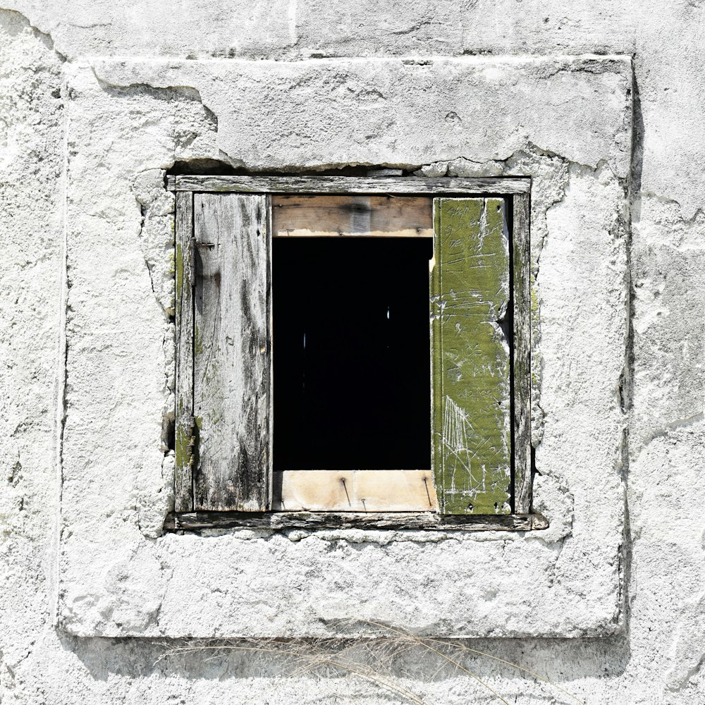 finestra di legno verde su parete di cemento bianco