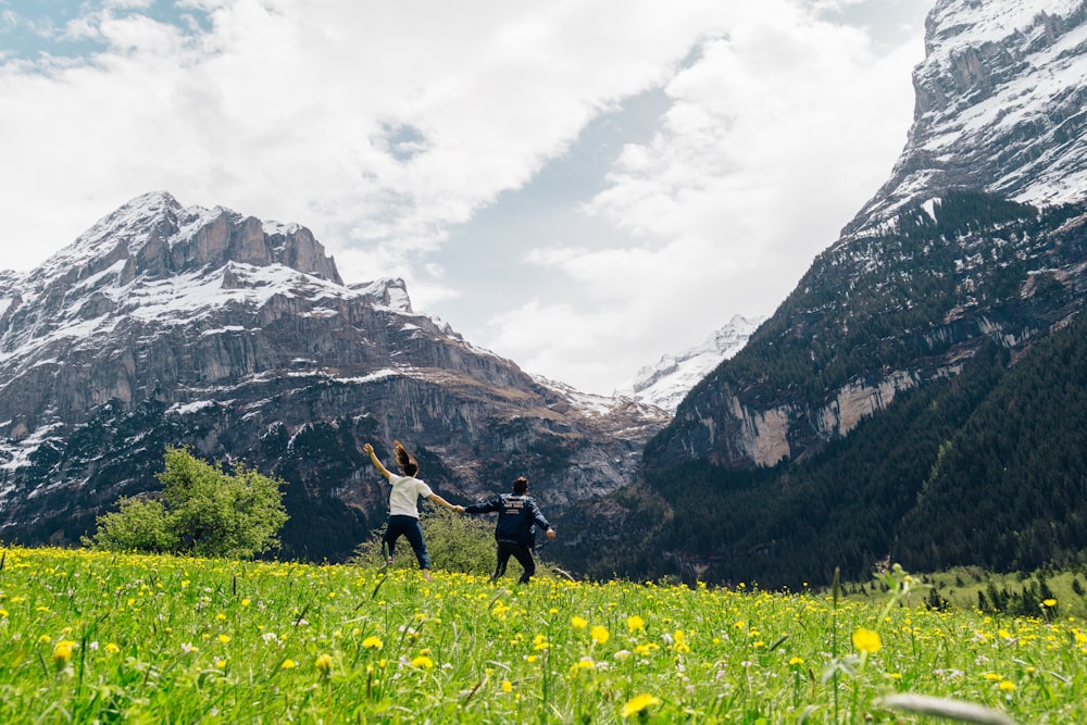 a couple of people standing on top of a lush green field