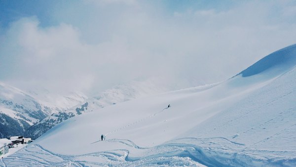 Two people hiking on snow covered hill during day — St. Anton am Arlberg, Austria