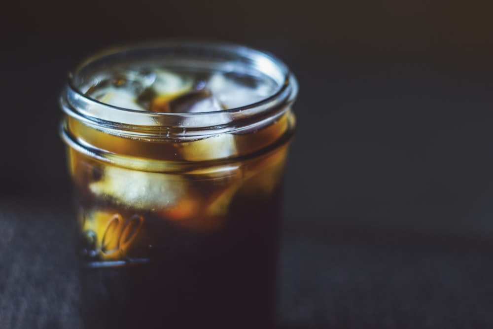 black liquid with ice cubes on Mason jar