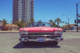 Close-up of the pink Cadillac gleaming under neon lights, capturing the spirit of classic rock and roll.