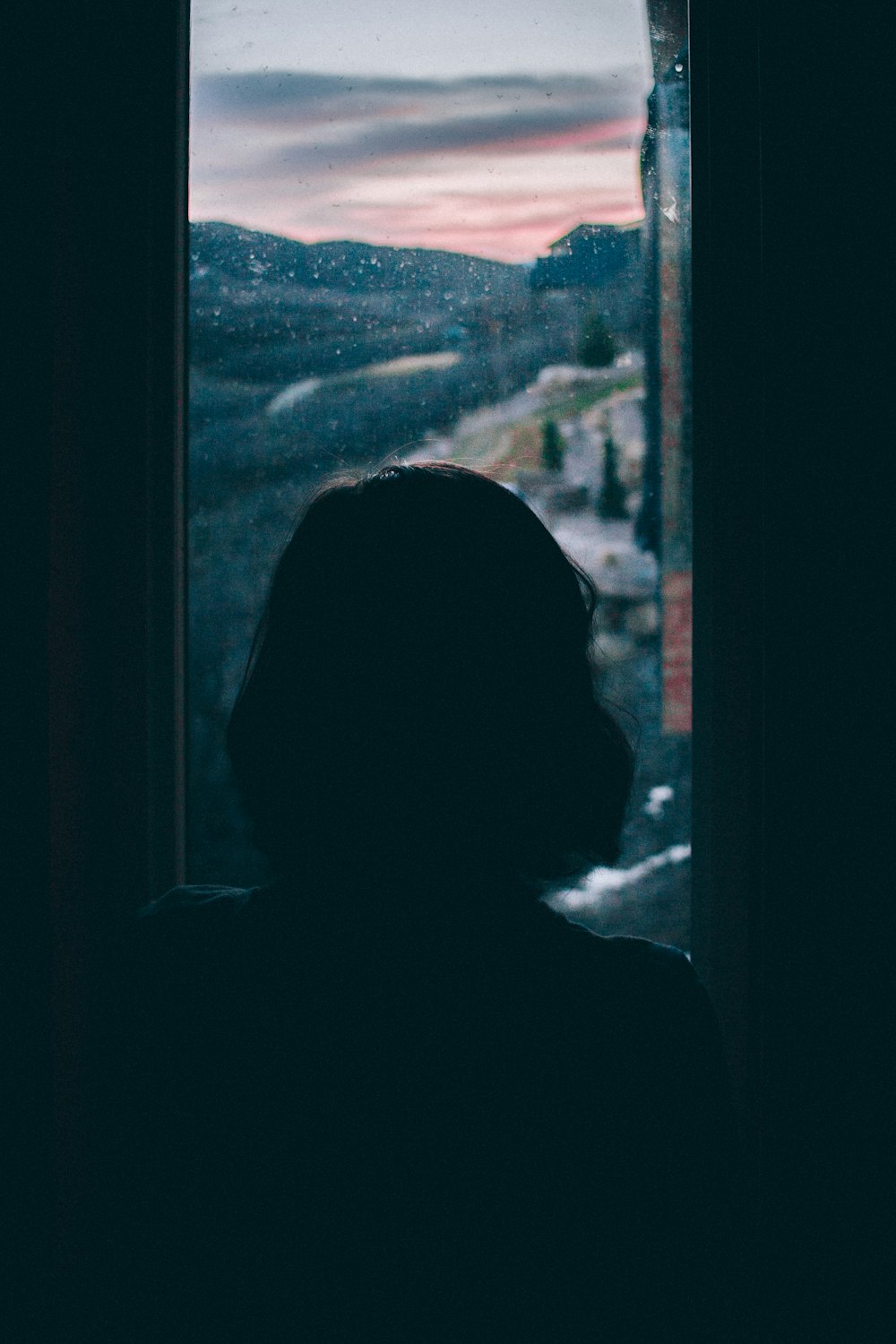 Frauensilhouette mit Blick ins Außenfenster