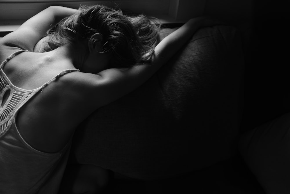 베개에 누워있는 여자의 회색조 사진