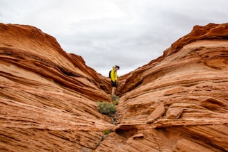 person in between rock formation during daytime