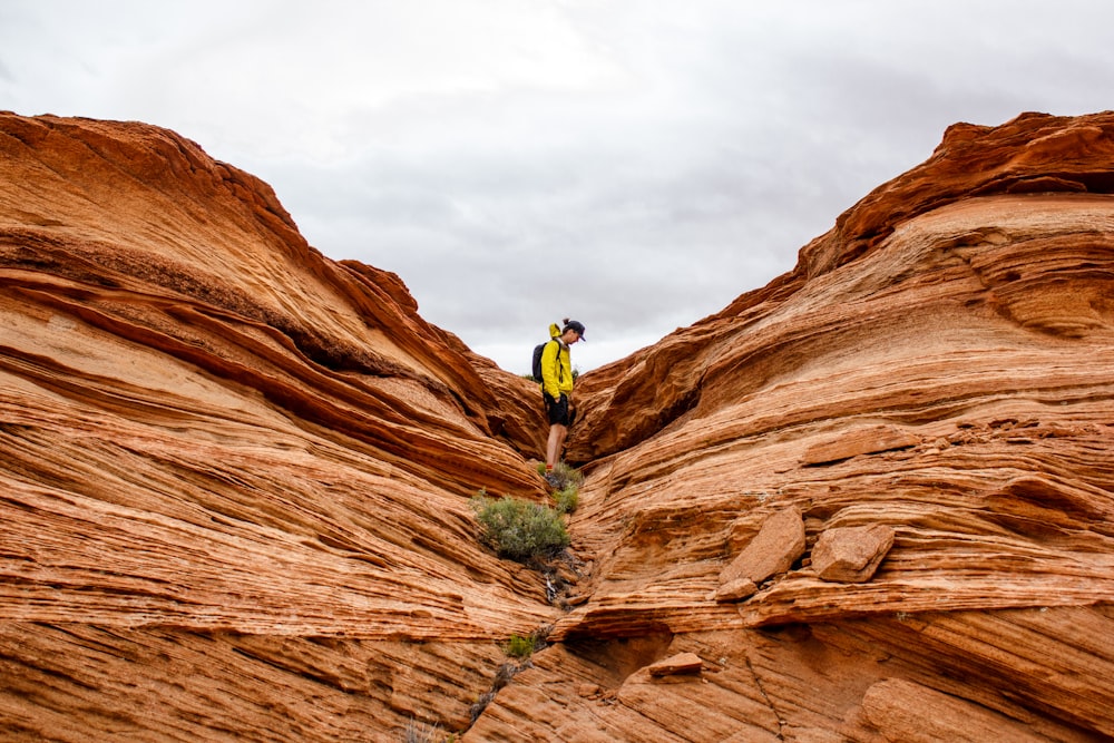 person in between rock formation during daytime