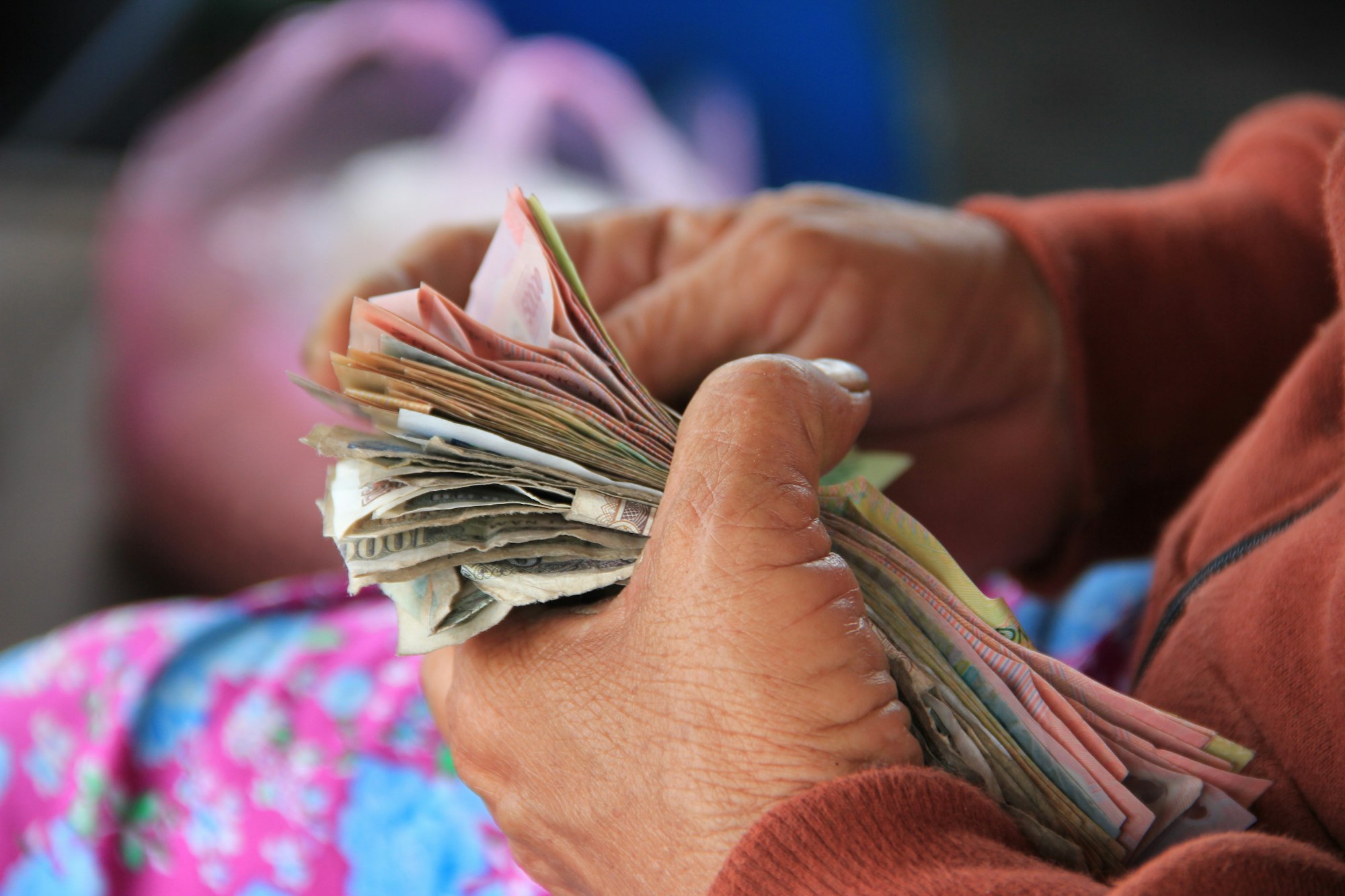 Returning back from a day at the market, a Vietnamese vendor counts her hard-earned money aboard a local ferry.