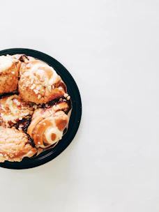 An assortment of delicate pastries arranged on a white ceramic plate with terracotta accents.
