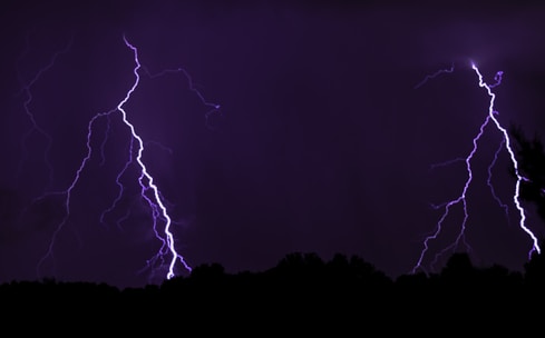 Close-up of yellow lightning bolts crackling wildly around the scientist's hair shooting up.