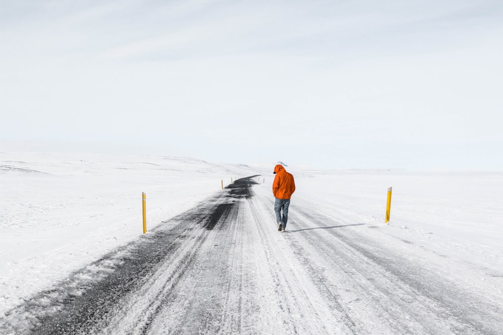 Mann geht auf verschneiter Straße