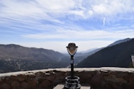 A scenic view of a mountain landscape with a watch in the foreground.