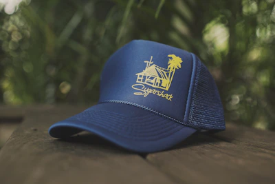 Close-up of a navy blue plain baseball cap resting on a rustic wooden table.