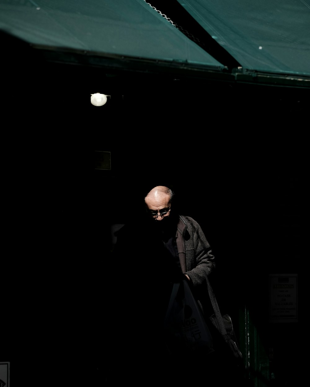 man wearing black jacket inside dark room