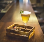 yellow liquid in clear long stem wine glass near cooked food