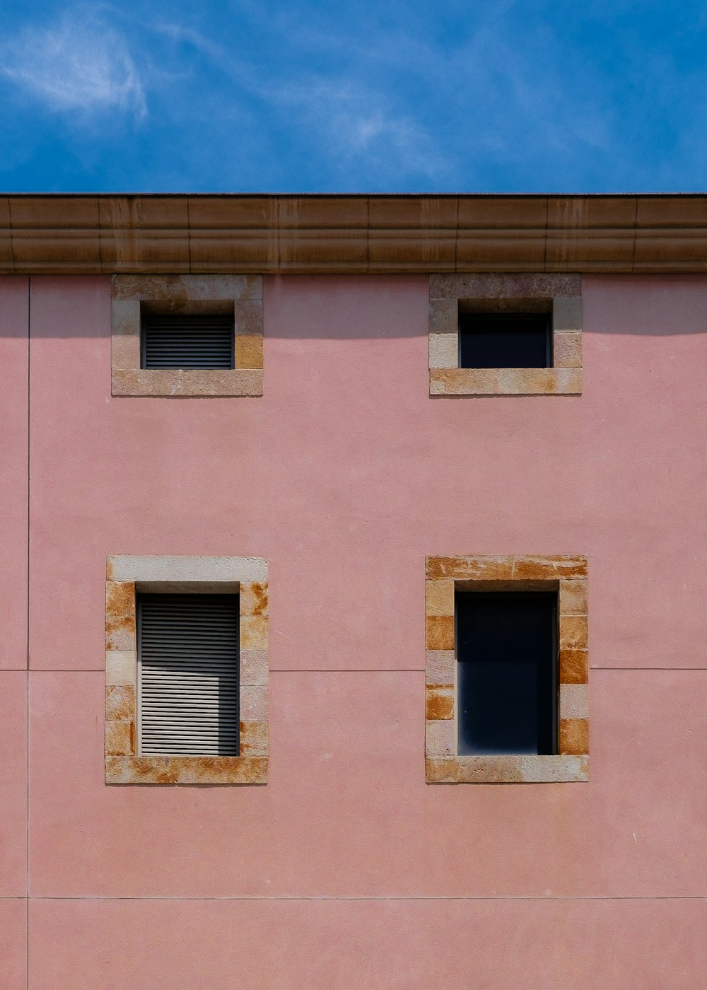 Photographie minimaliste d’un bâtiment en béton avec quatre fenêtres