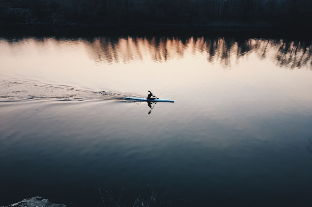 person using boat on lake during daytime