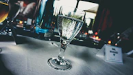 Refreshing glass of alkaline water with bubbles, placed on a clean white countertop.