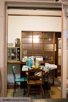 A cozy dining nook featuring a rolling cart doubling as both storage and a serving station with elegant dishware.