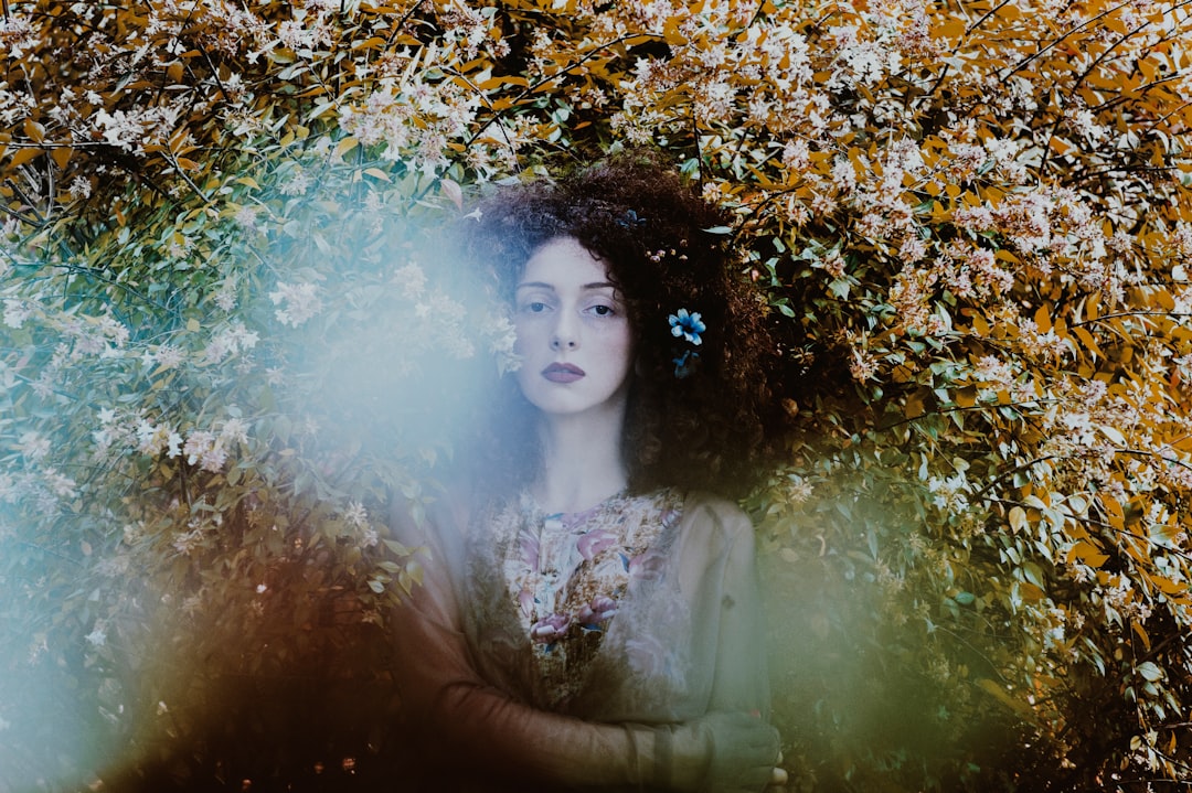 woman standing under floral palnt