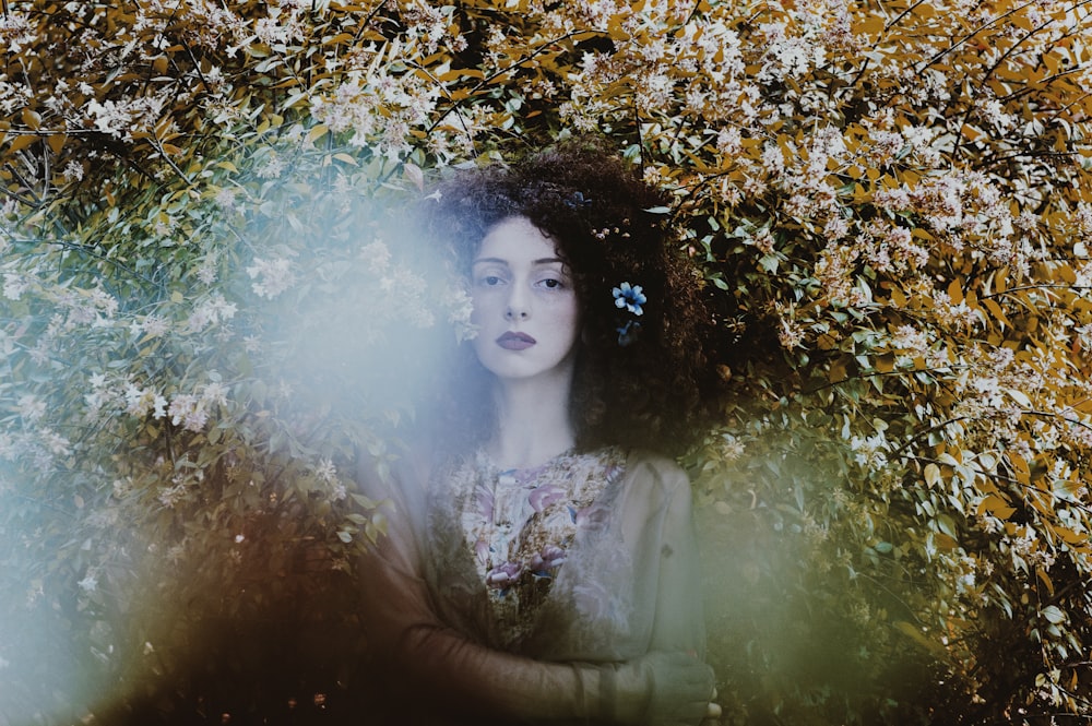 woman standing under floral palnt