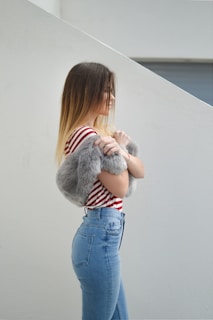 woman with pink fur scarf near wall