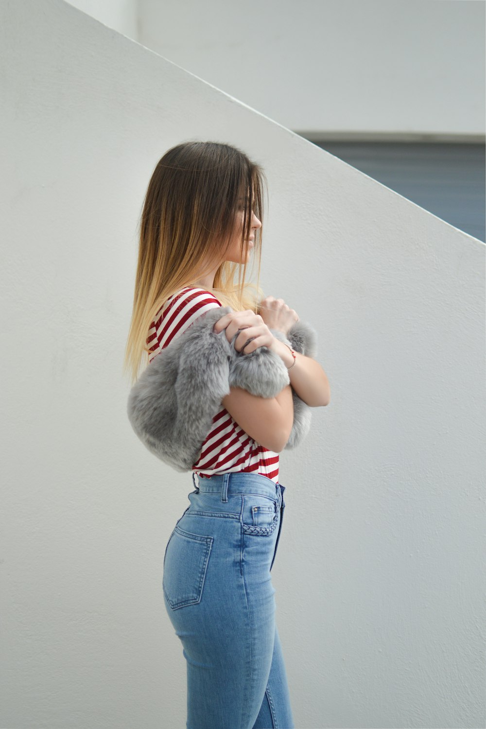 woman with pink fur scarf near wall