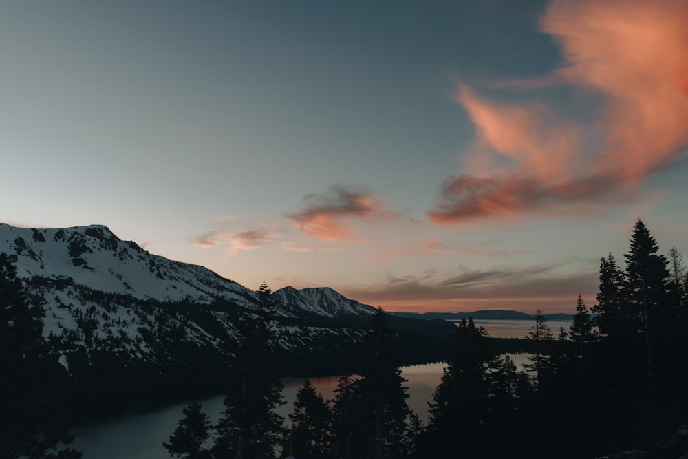 body of water within snow-covered mountain range during daytime