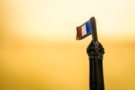A subtle French tricolor flag displayed in a modern training room filled with engaged participants.