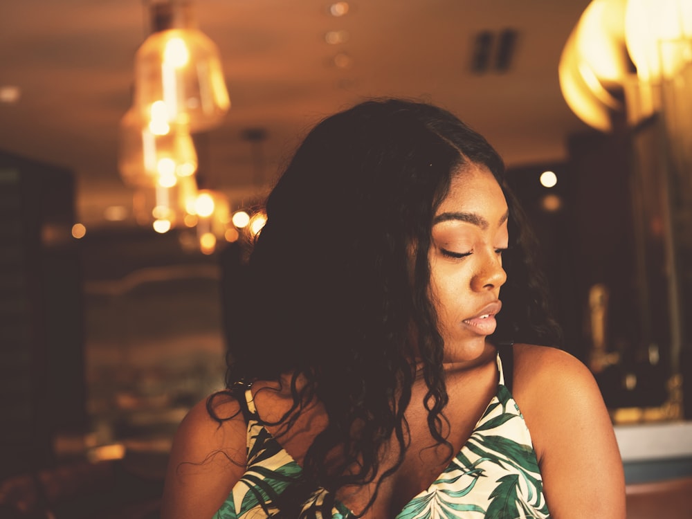 woman wearing white and green floral spaghetti strap shirt