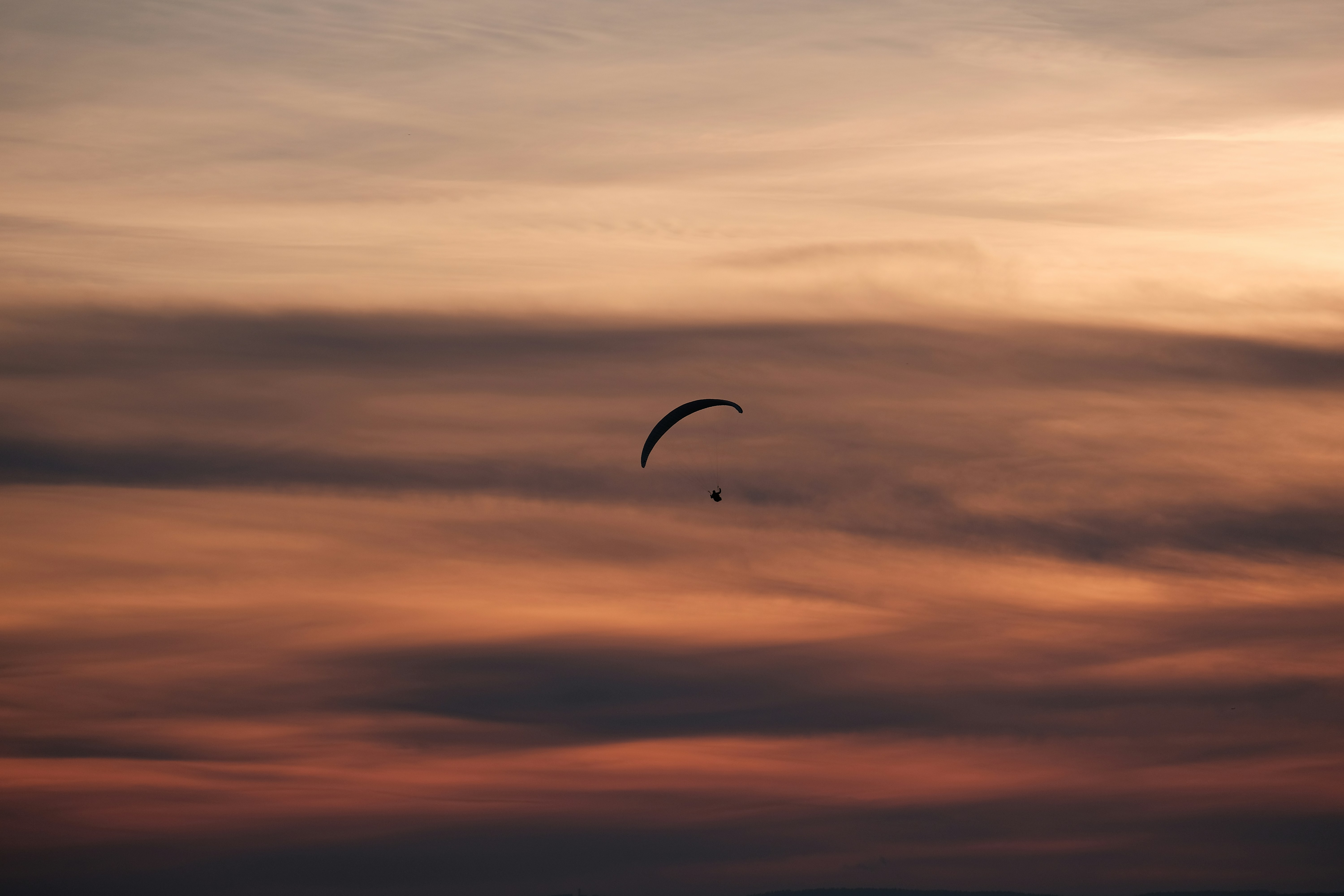person gliding parachute in sky