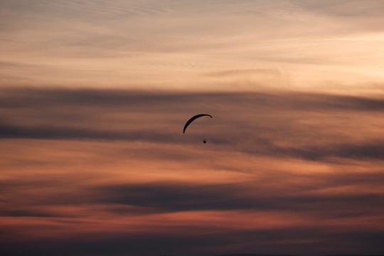 person gliding parachute in sky in La Croisette France