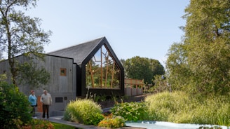 A beautiful house with a modern roof design surrounded by greenery.