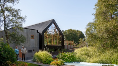 A welcoming real estate agent showing a modern home to a happy couple