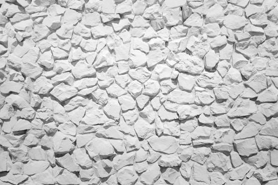 a white stone wall with small rocks on it