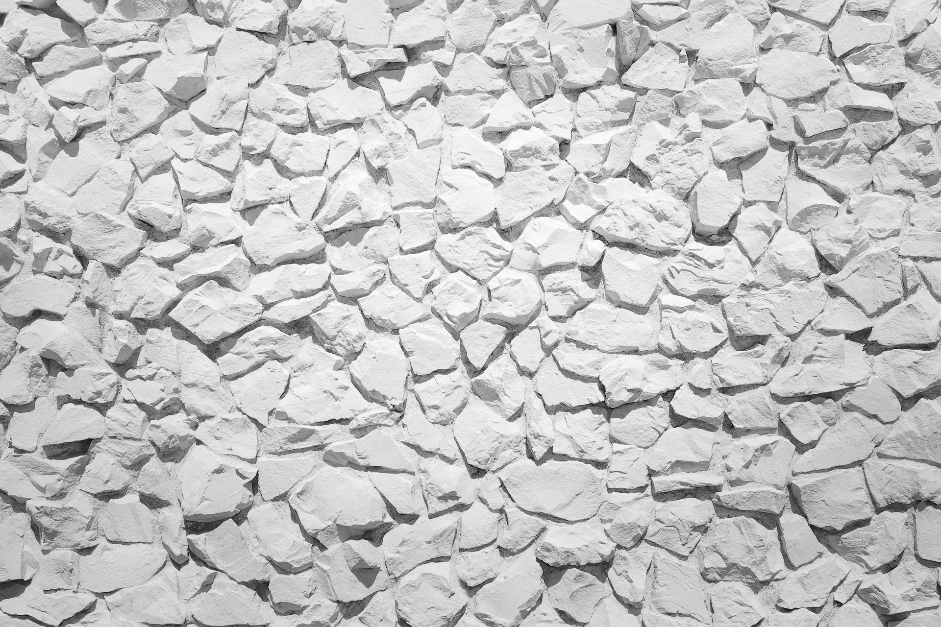 a white stone wall with small rocks on it