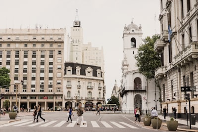 woman crossing pedestrian lane between tall buildings argentina google meet background