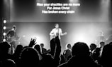 man standing on stage and playing guitar