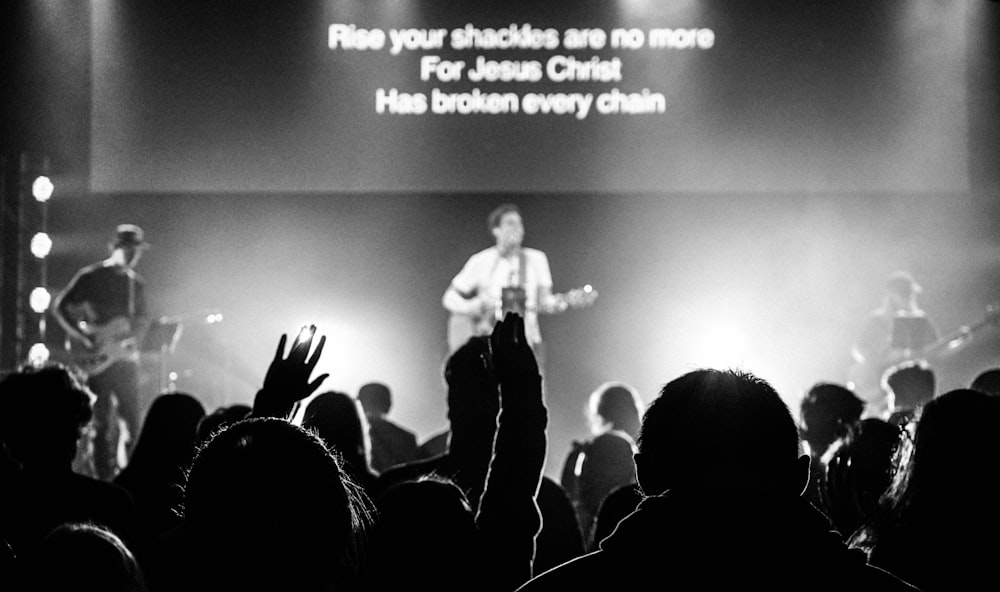 man standing on stage and playing guitar