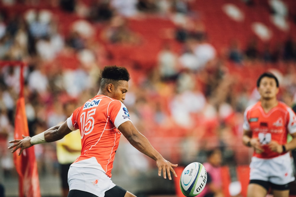 joueur de rugby frappant dans un ballon de rugby