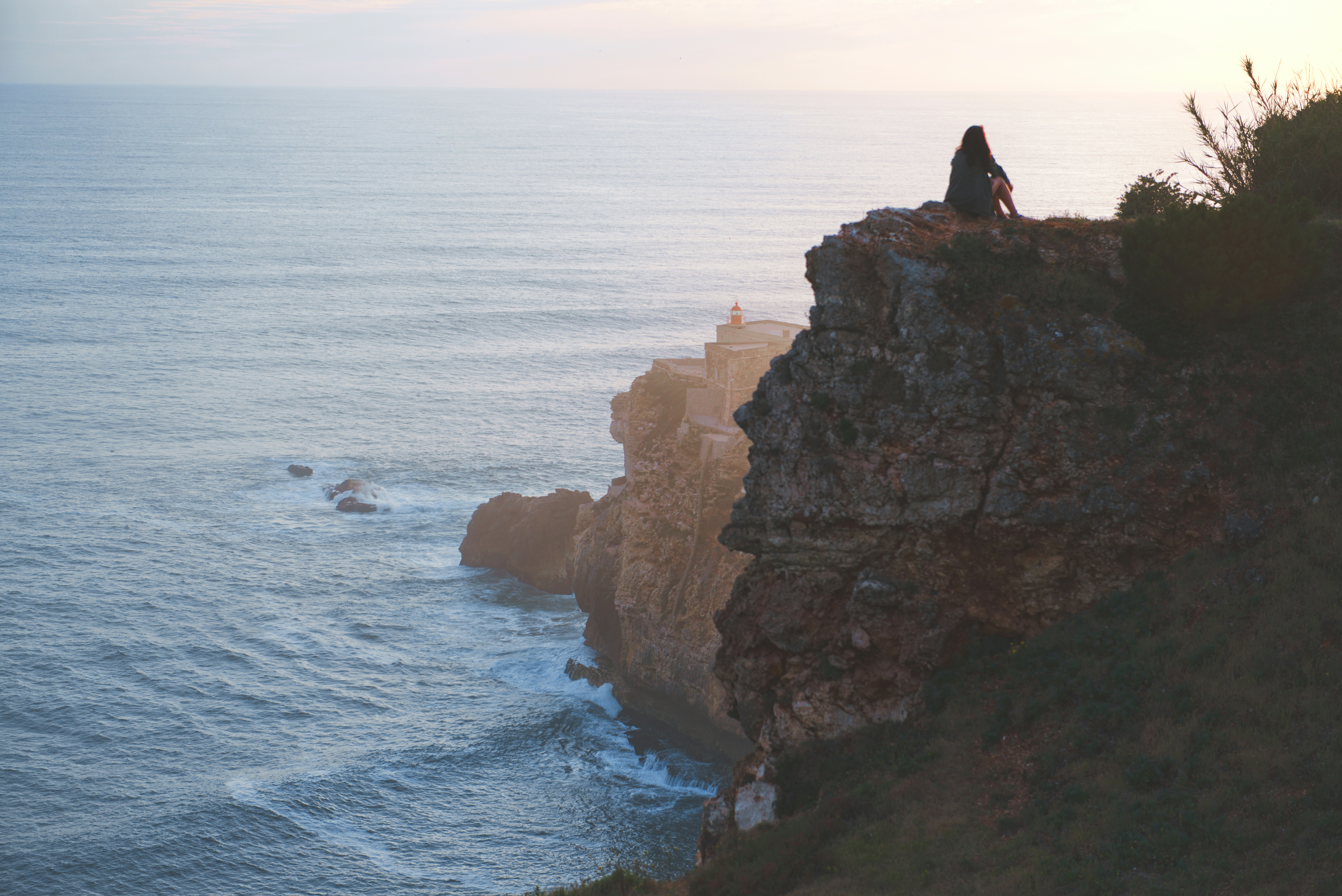 woman sitting on rock near cliff, 