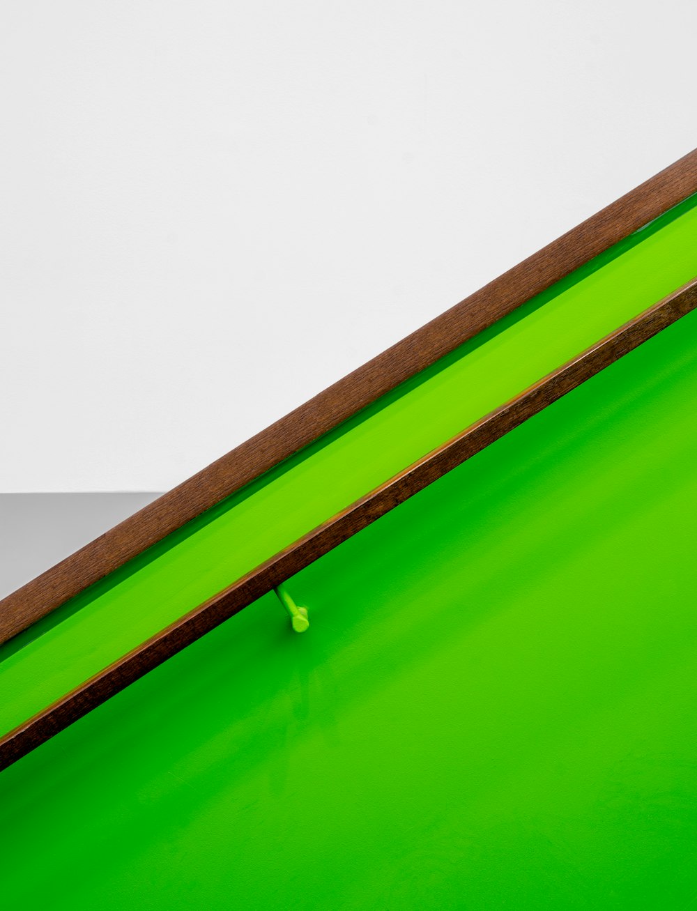 a close up of a green table with a white wall in the background