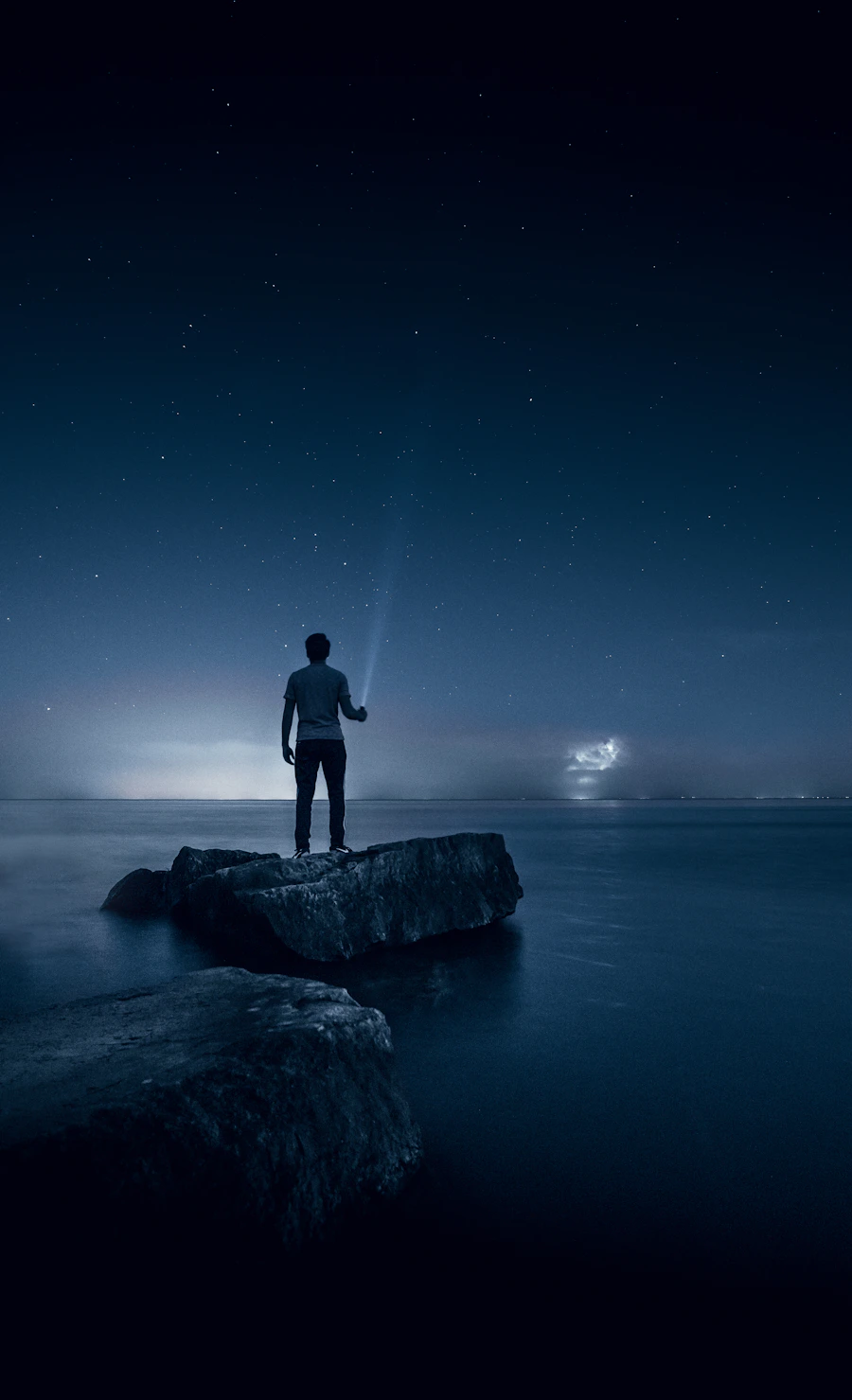 A figure beneath a star-strewn sky