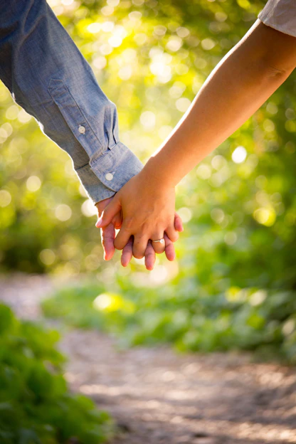 A warm, inviting photo of a couple holding hands in a sunlit church garden, symbolizing faith and connection.