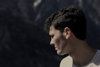 man standing at the edge of the cliff looking down