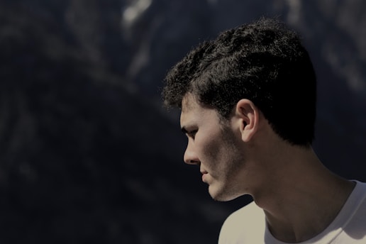 man standing at the edge of the cliff looking down