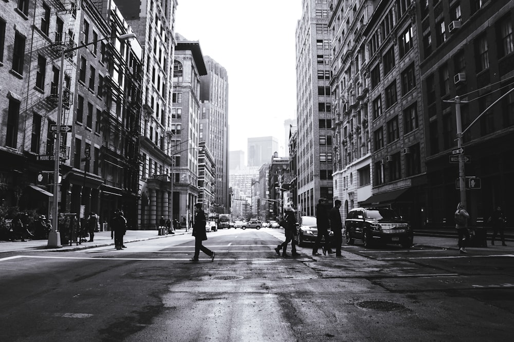 Photographie en niveaux de gris de personnes traversant la rue