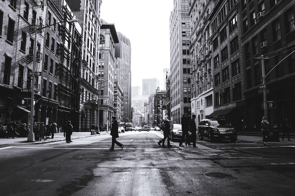 Graustufenfotografie von Menschen, die die Straße überqueren